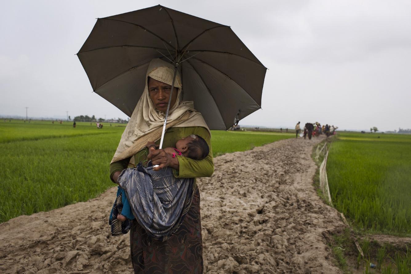 a mother and child walk to safety in Bangladesh