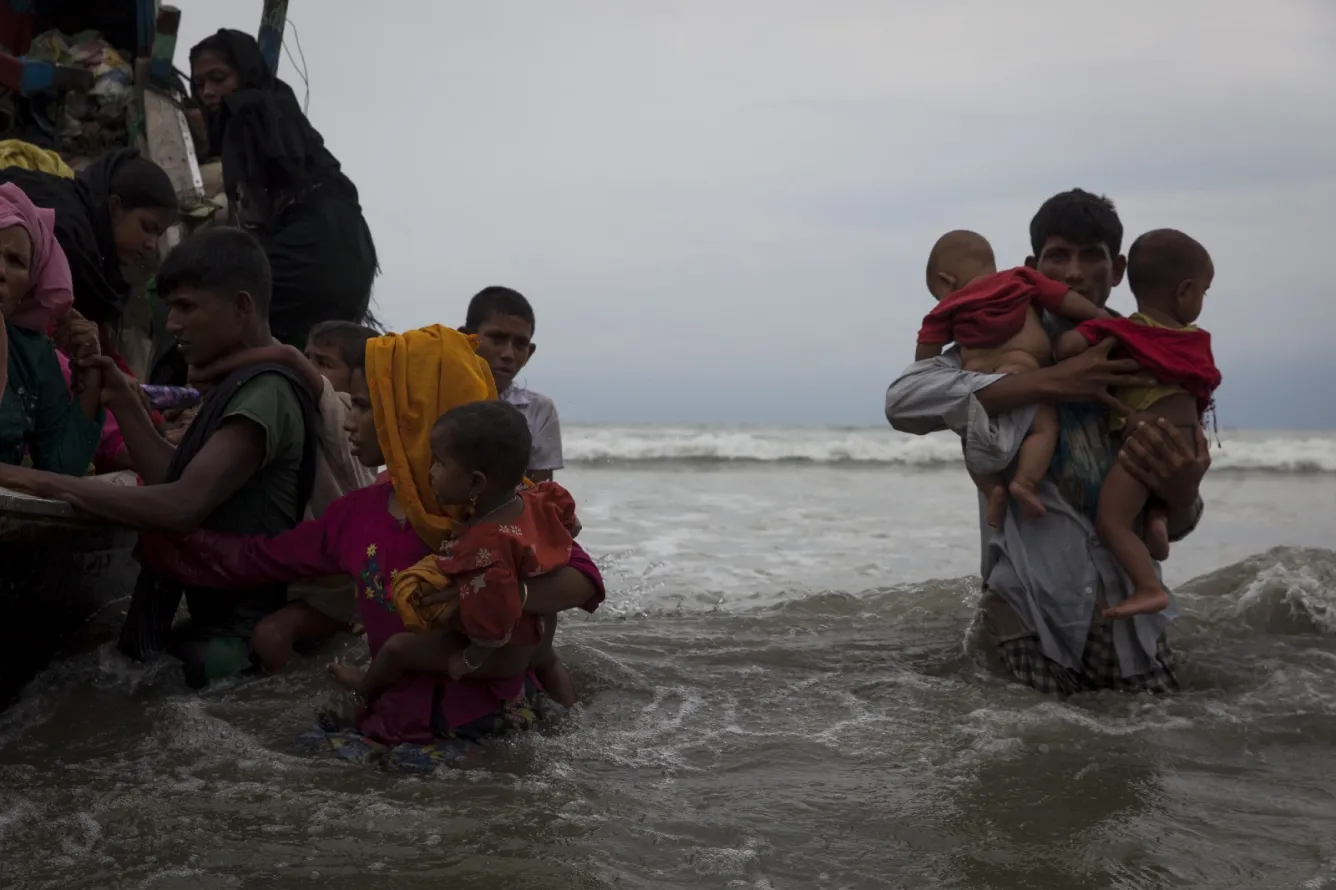 refugees walk ashore at Shalmpur beach