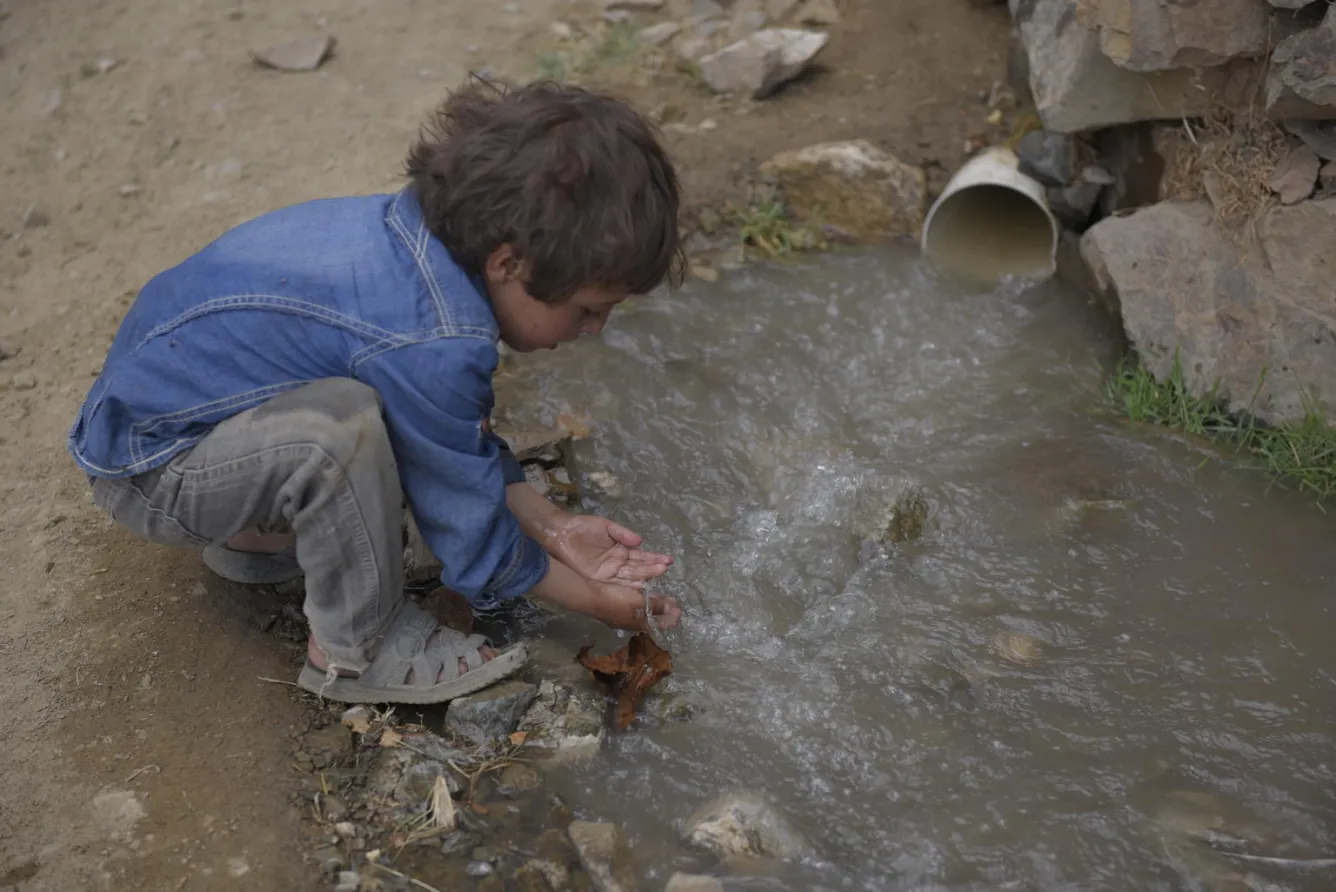 Yemeni child washing his hands in dirty water