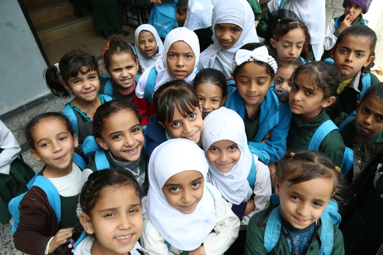 children with UNICEF-donated bags and education supplies
