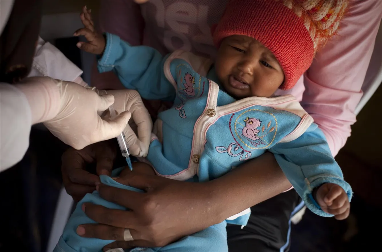 An infant is vaccinated in a transit camp for third-country nationals fleeing the civil war in Libya, at the Ras Jedir border post.