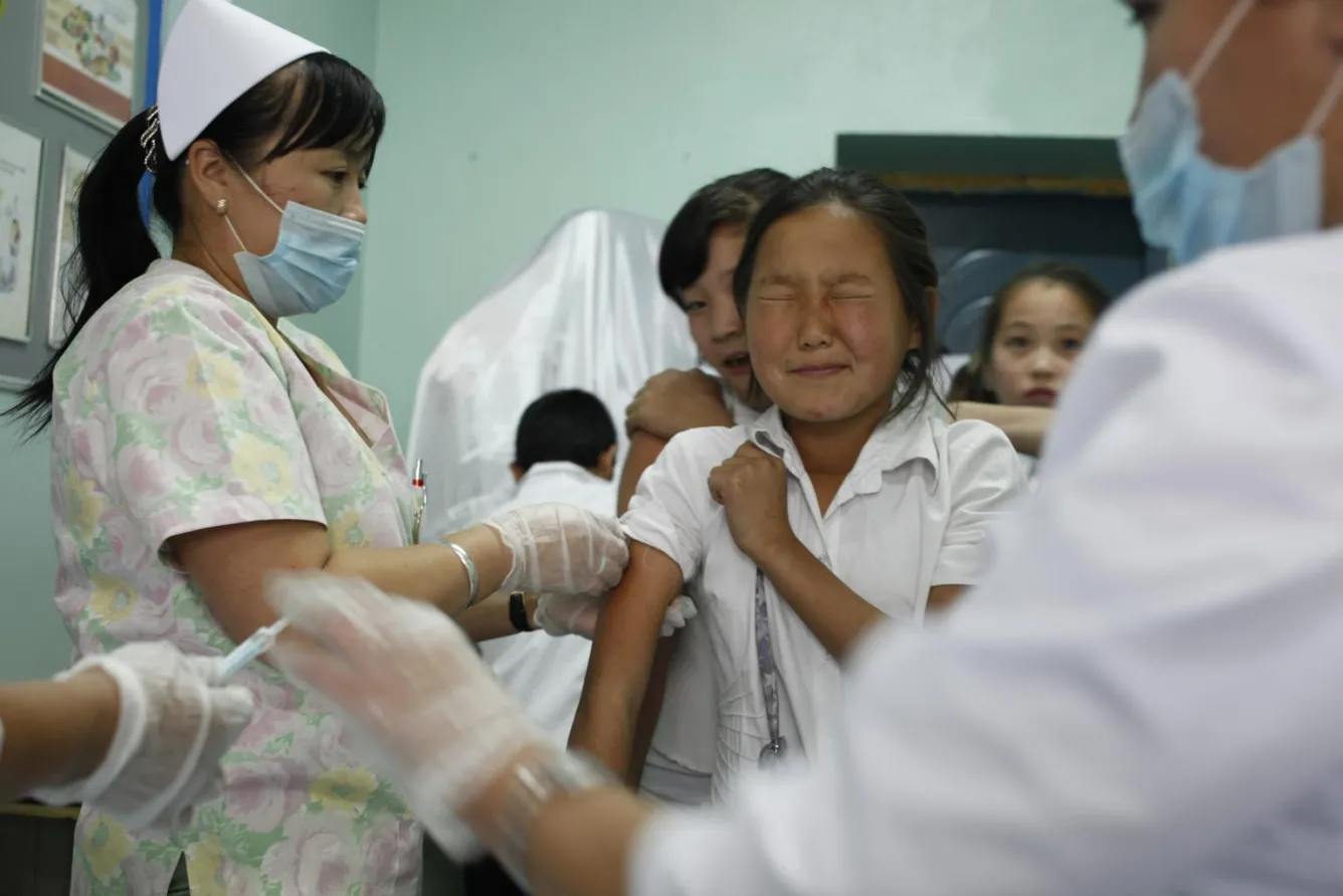 A girl winces while a health worker vaccinates her against measles and rubella at a school in Ulaanbaatar.