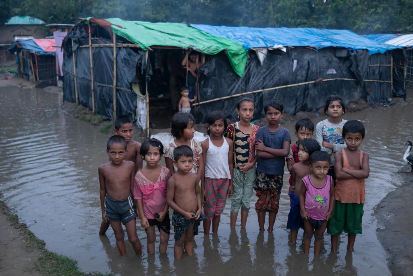 rohingya refugee children standing in the rain