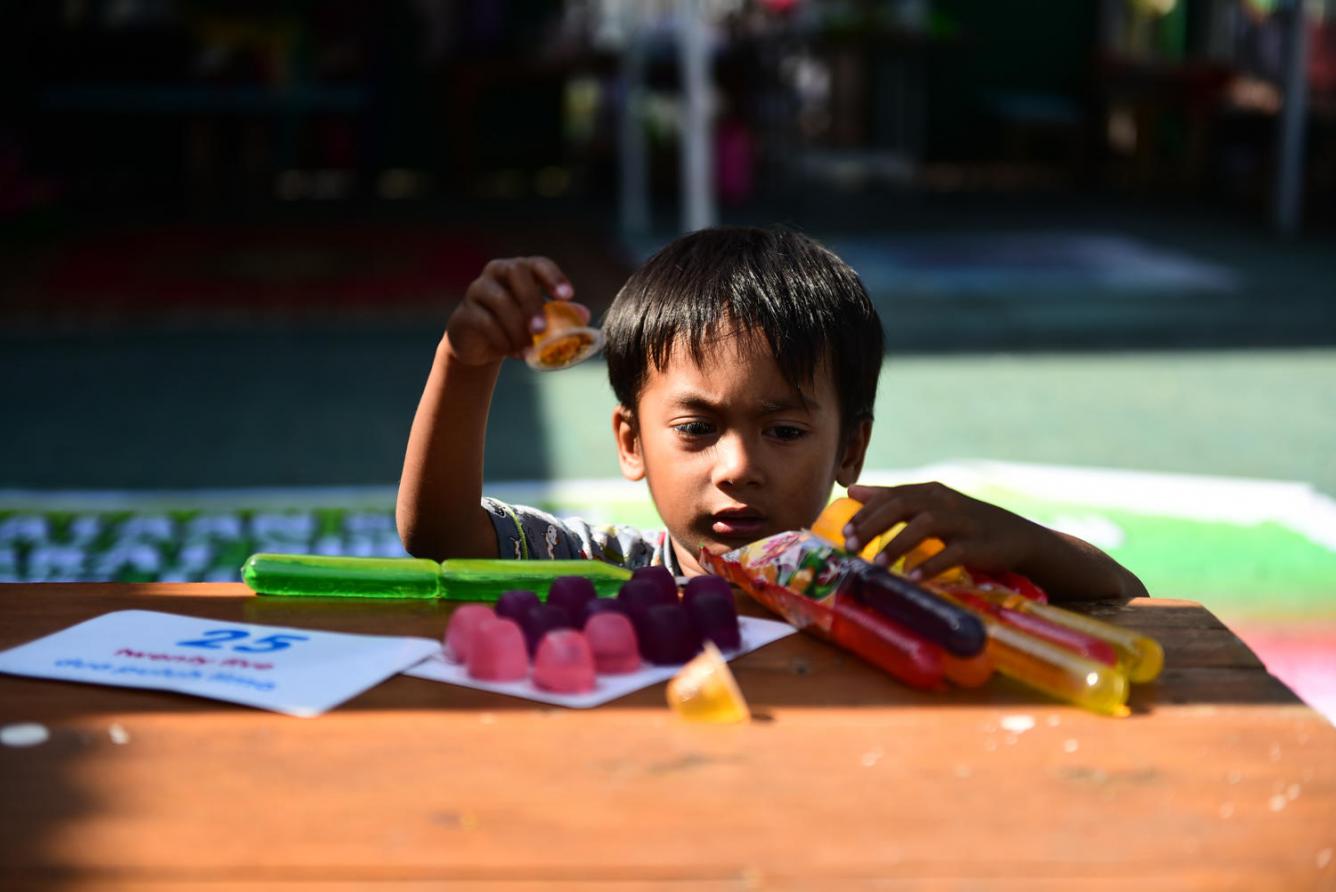 boy plays with packaged food, Indonesia