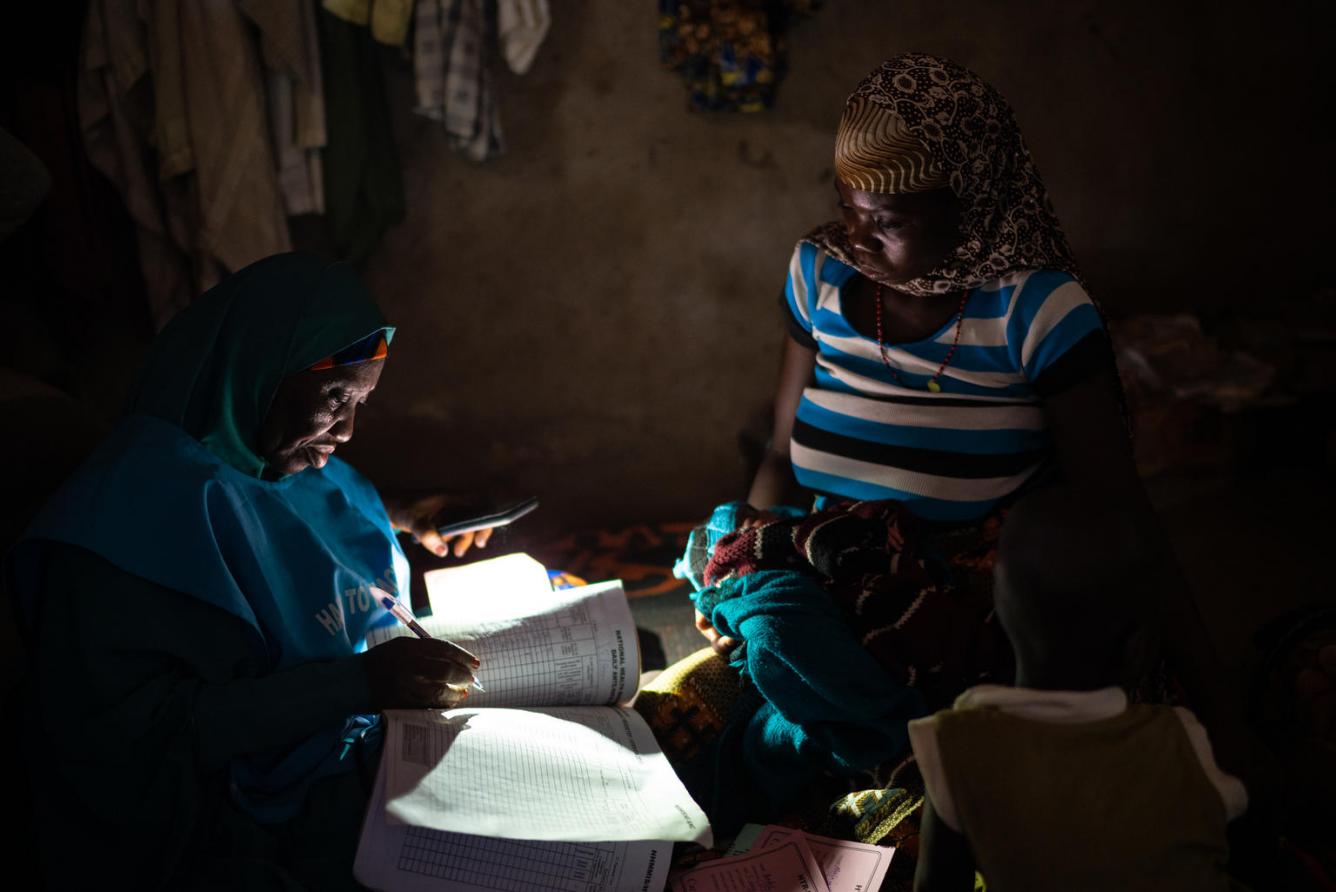 A UNICEF midwife makes notes during a house visit.