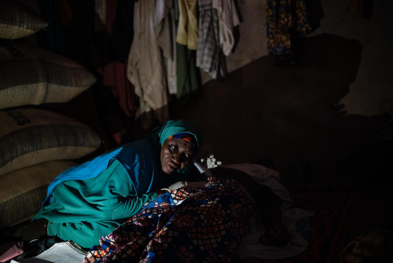 A woman wearing a green head covering sits in a UNICEF-supported MCH clinic.