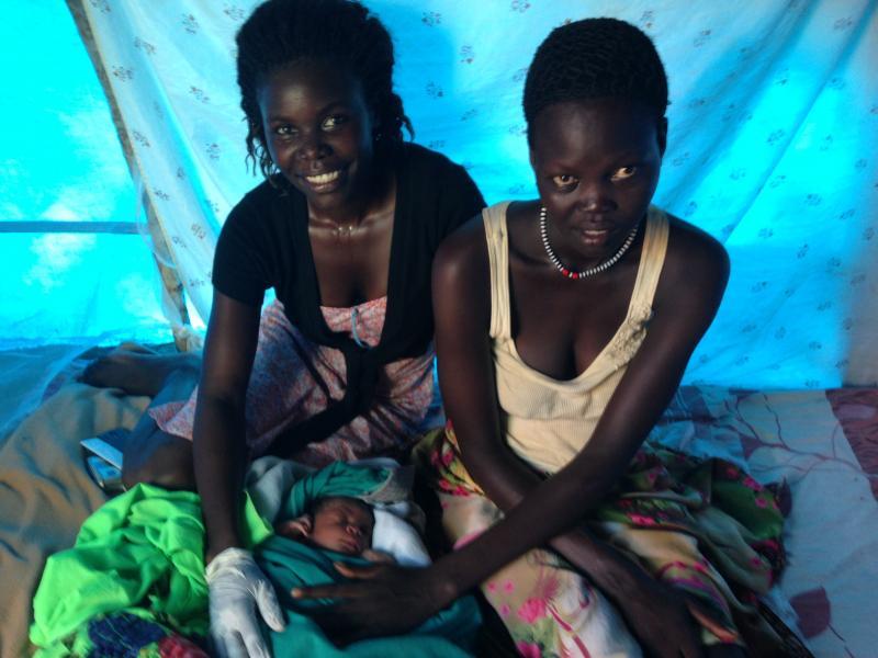 Florence (left) – a trained midwife – checks on the baby, and his mother Kuei, shortly after the baby’s birth.