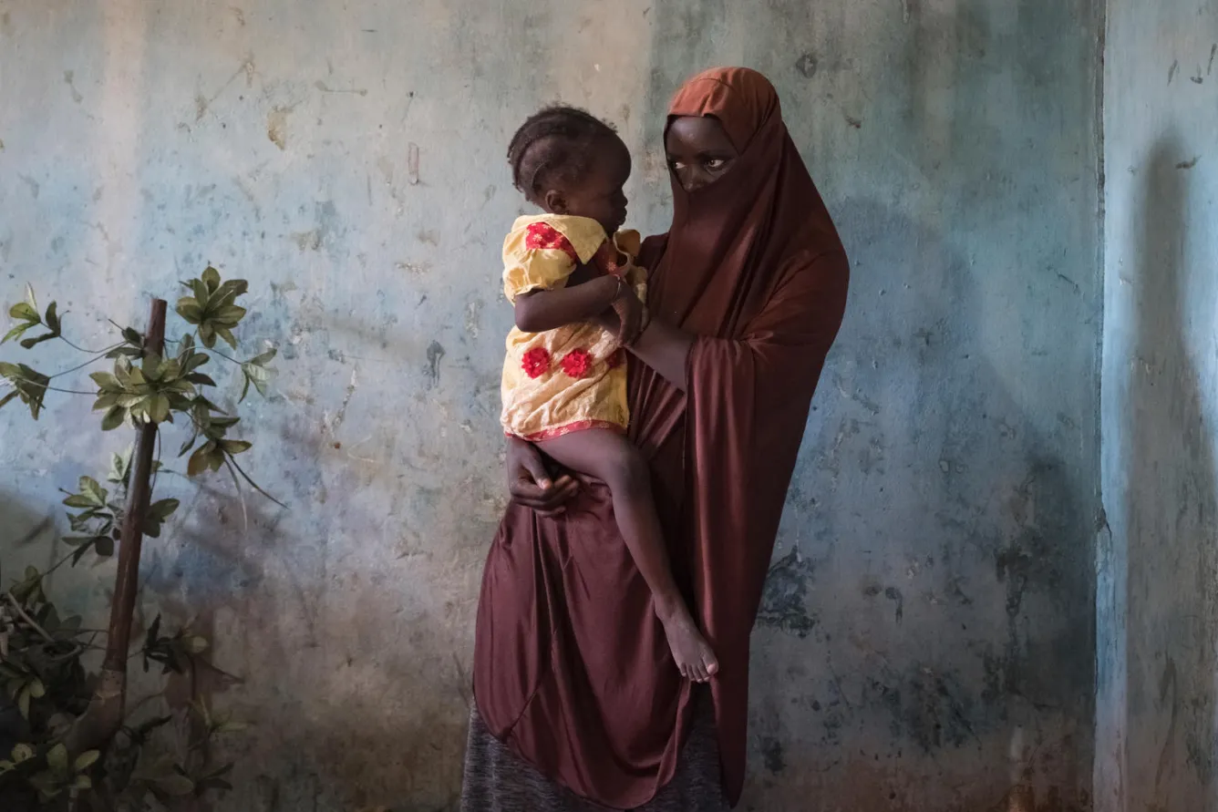 Une jeune fille tient son bébé
