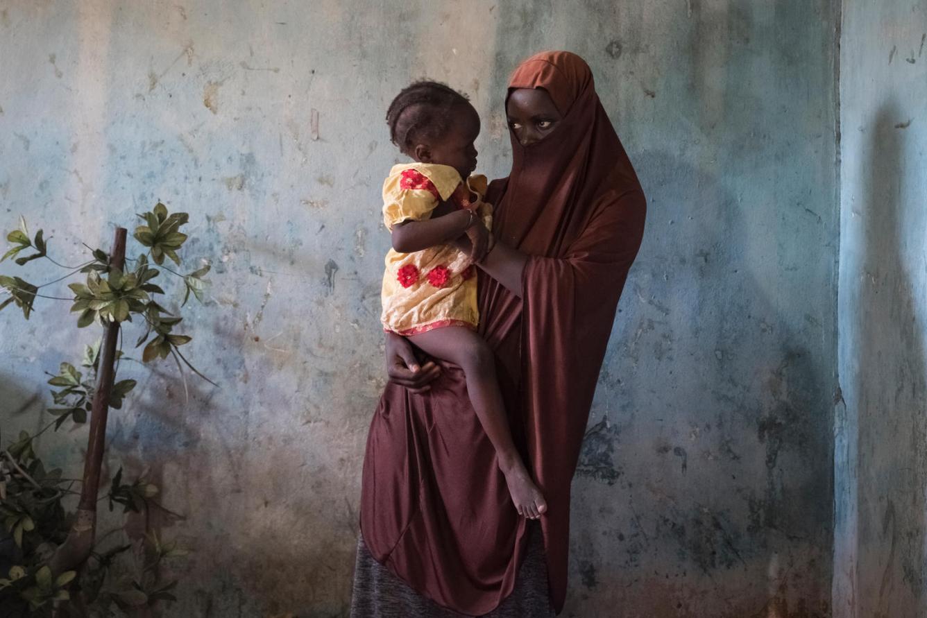 Une jeune fille tient son bébé