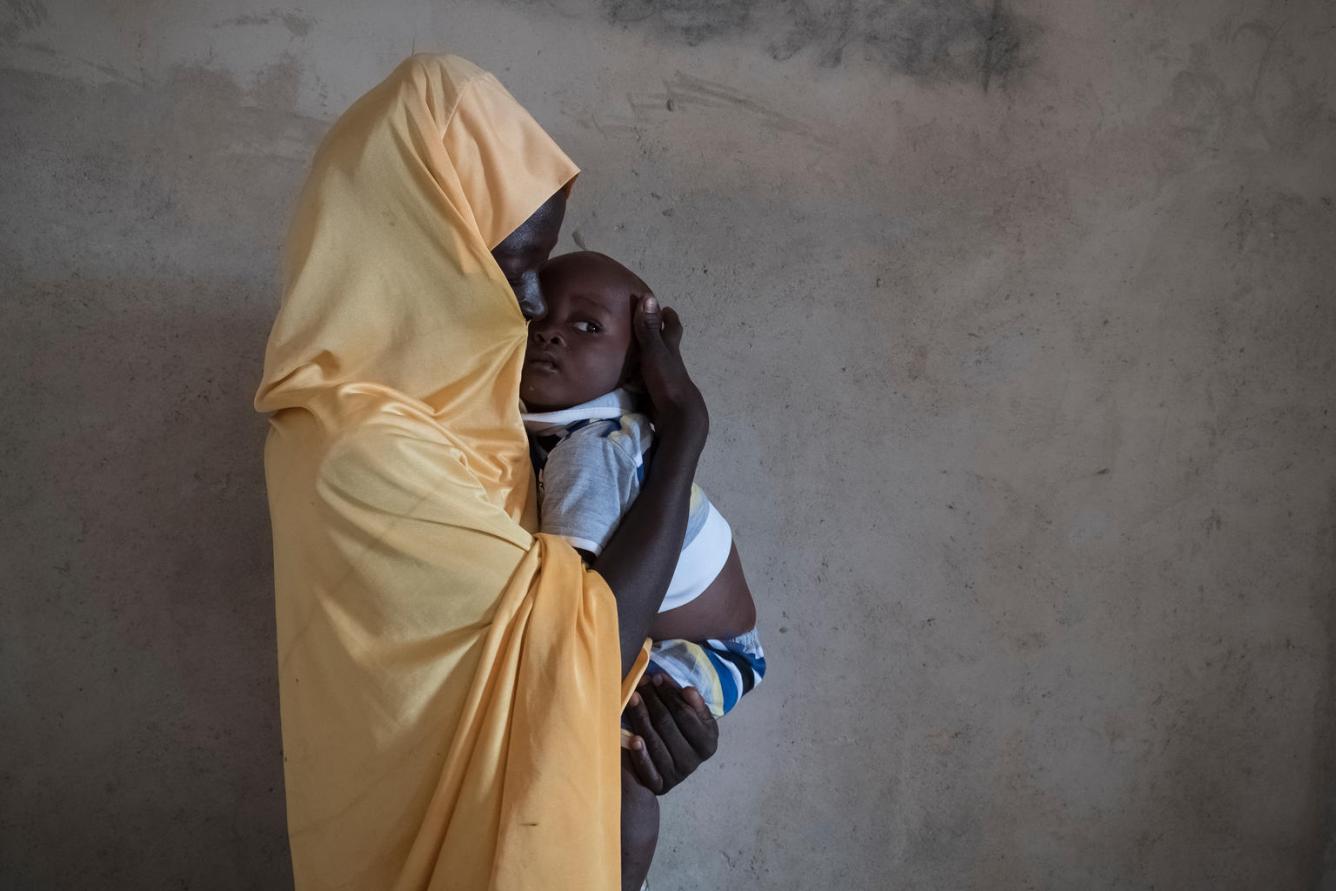 Une jeune fille tient son bébé