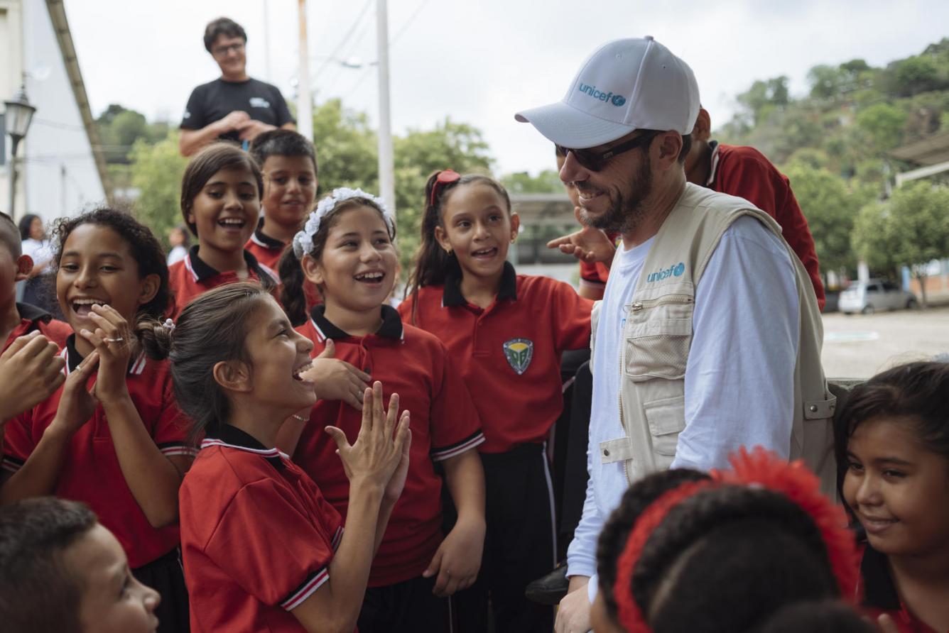 children interact with UNICEF worker