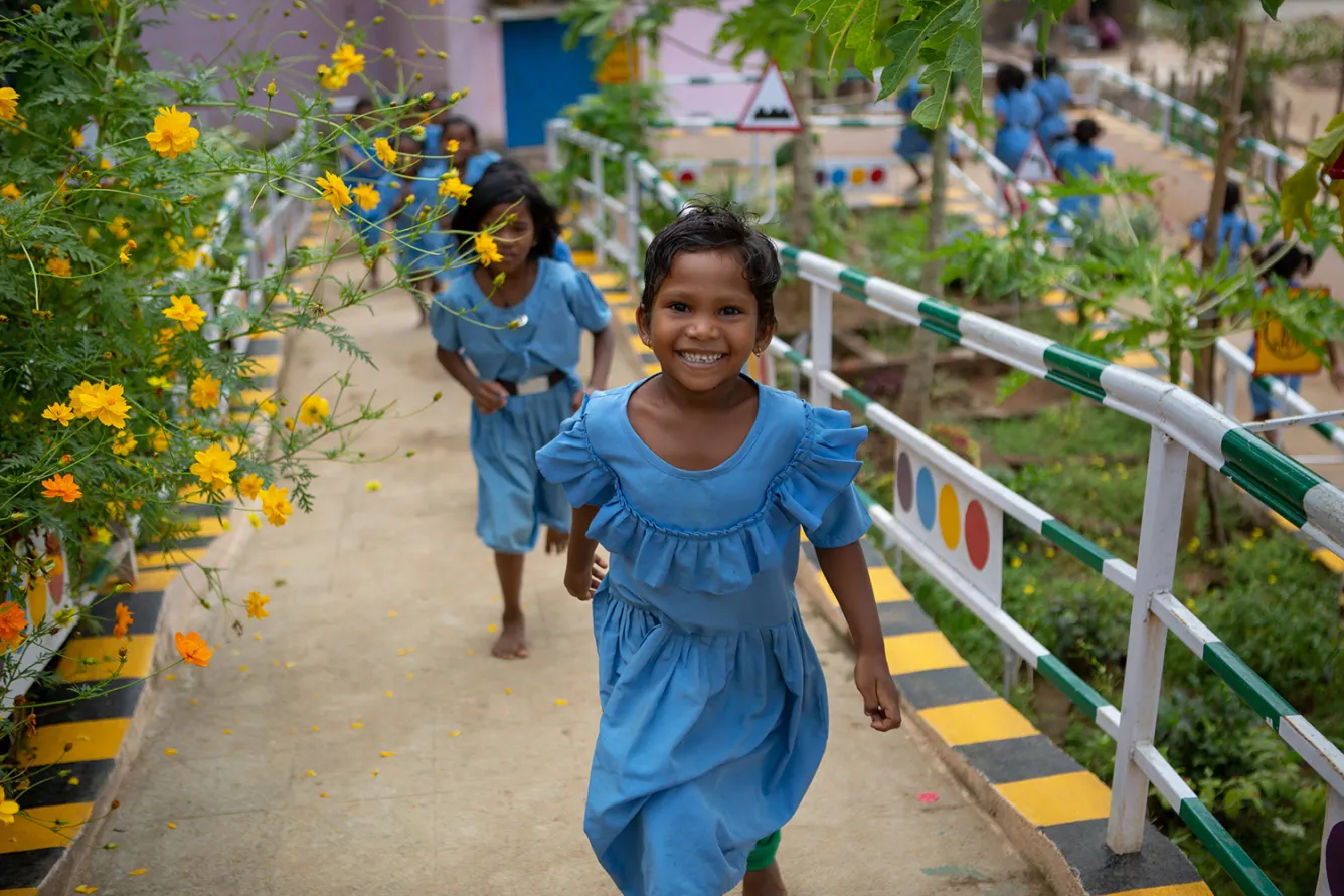 Young girl students run through a school campus. Convention on the Rights of the Child - 30th anniversary.