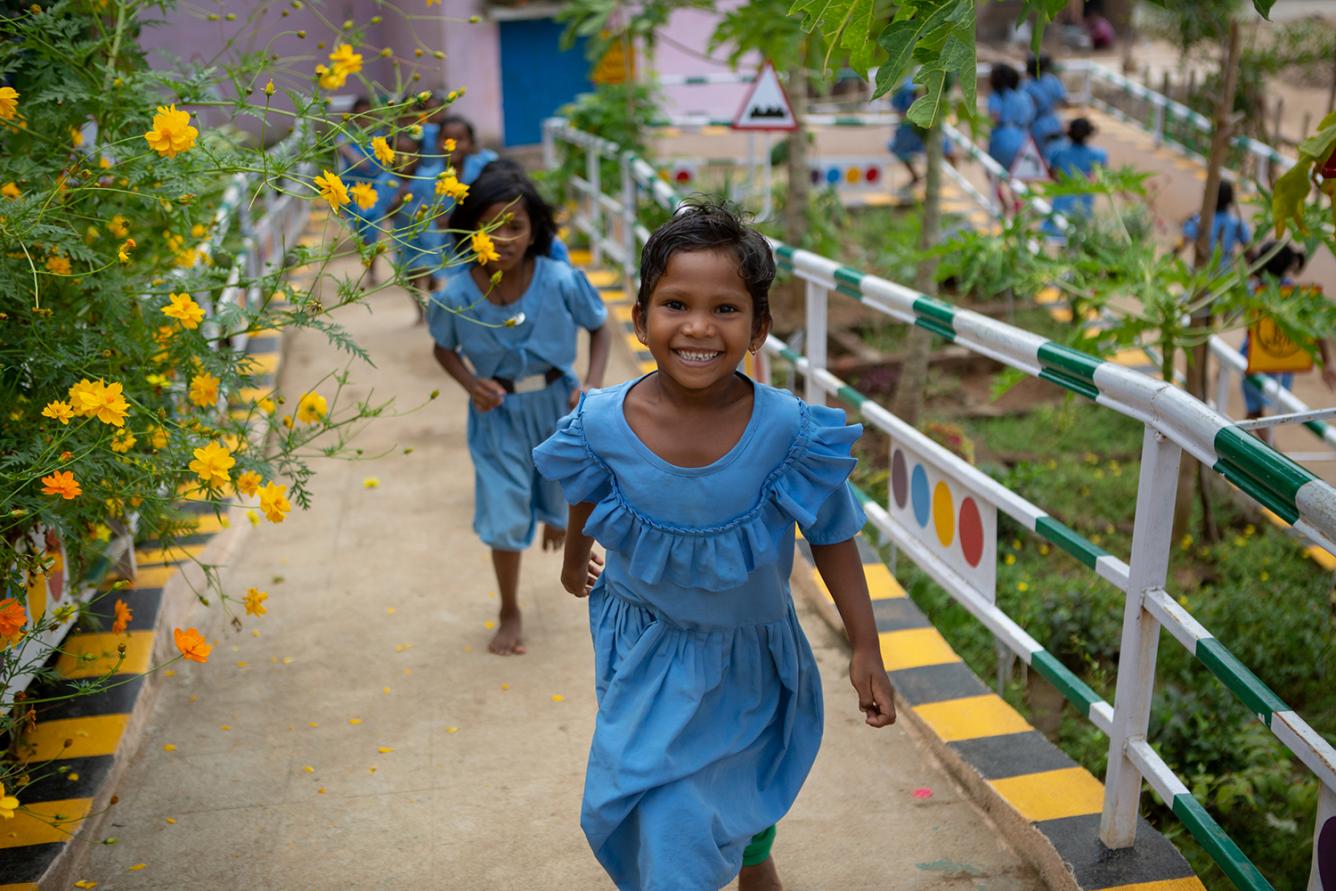 Young girl students run through a school campus. Convention on the Rights of the Child - 30th anniversary.