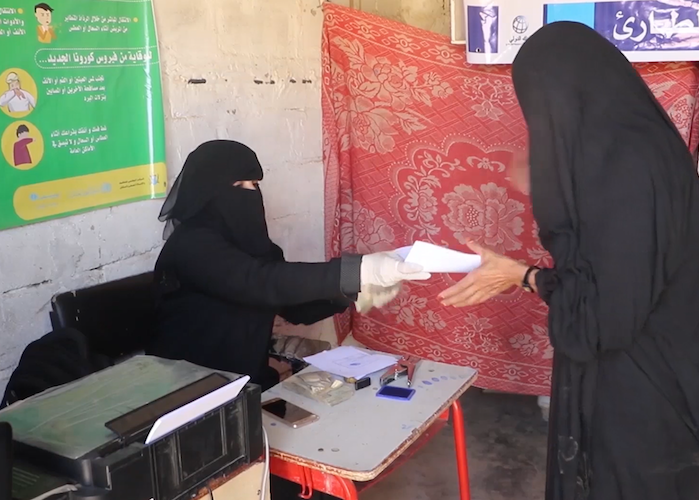 700w.a staff member while performing the cash transfer process to pay the money for the beneficiaries in Yemen's Sada'a region _0.png