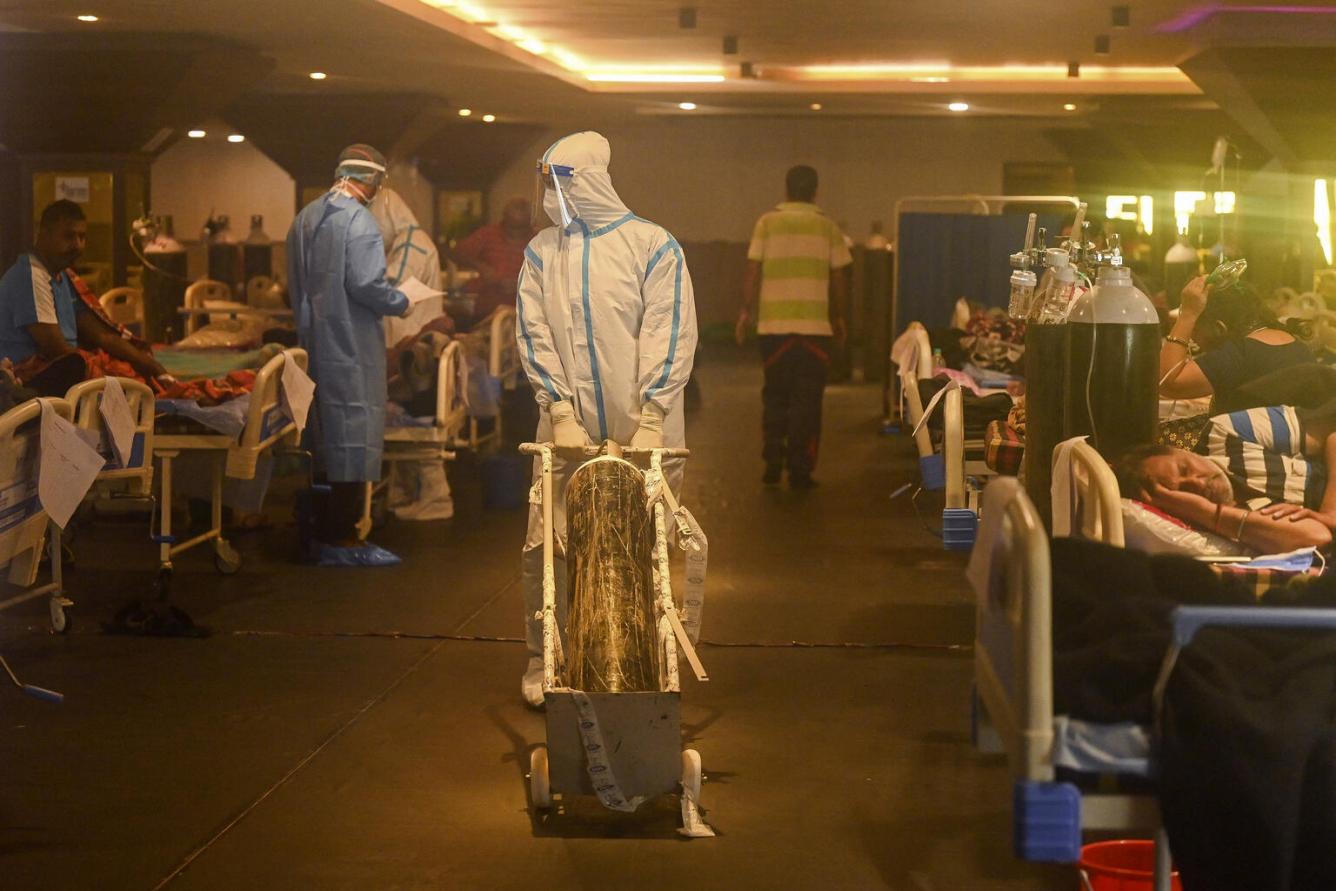 Un travailleur de la santé portant un équipement de protection individuelle (ÉPI) avec de l’oxygène en Inde, dans une salle de réception transformée en salle COVID-19 à New Delhi.