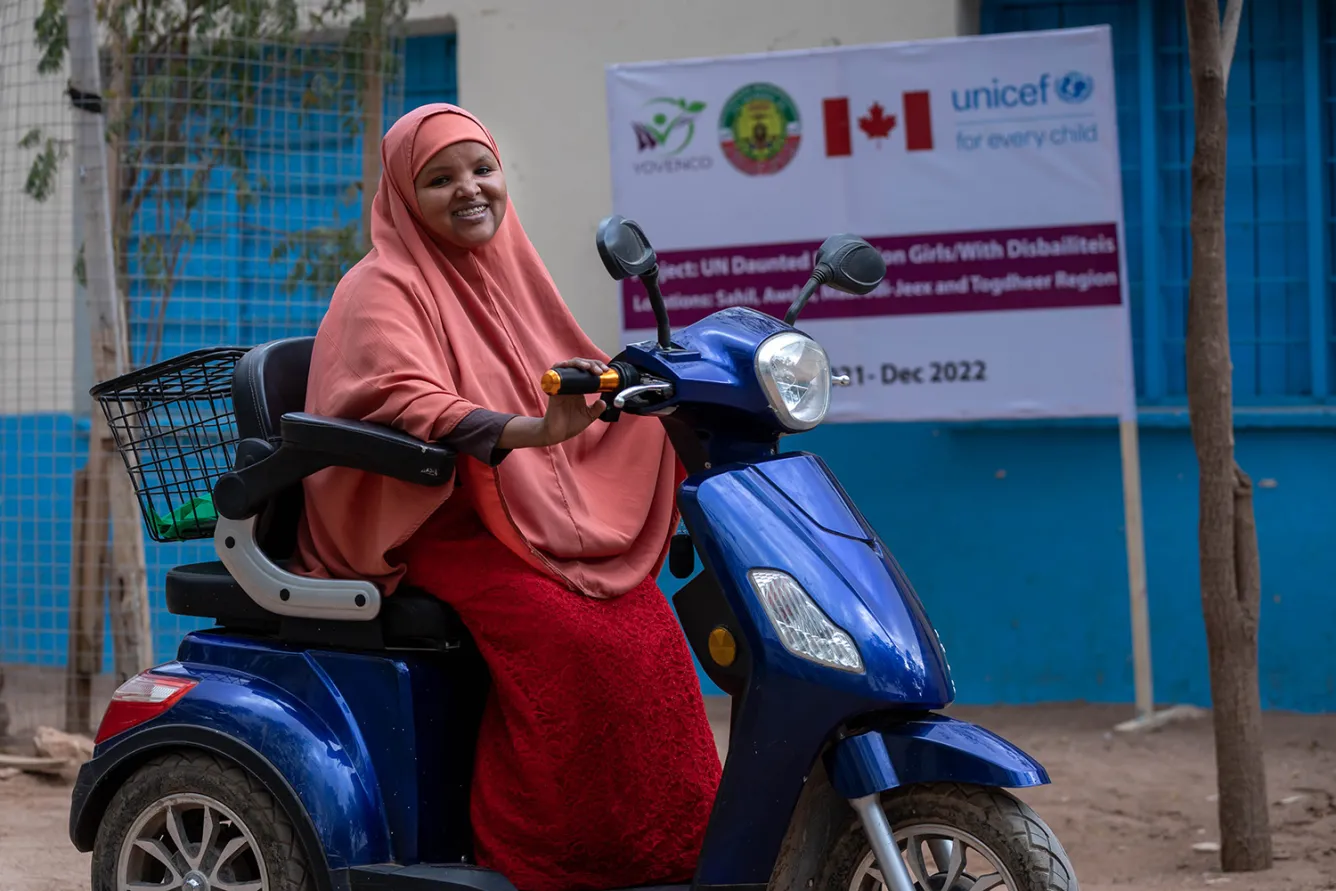 Jeune fille handicapée physique sur son vélo devant son école au Puntland, en Somalie.