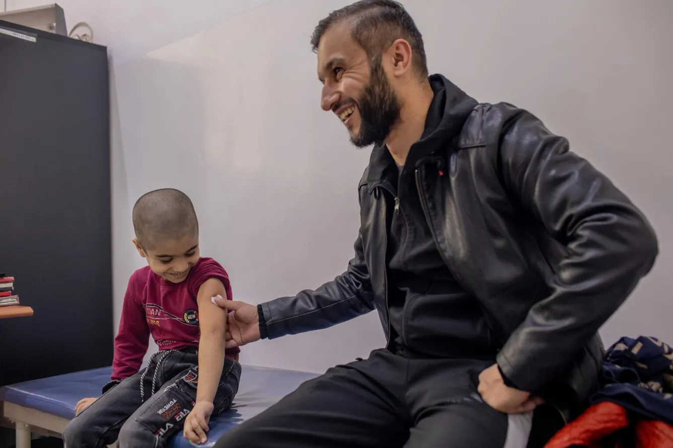 Muso Ahliddinzoda, 6 ans, se fait vacciner en compagnie de son père au Centre de santé Douchanbé.