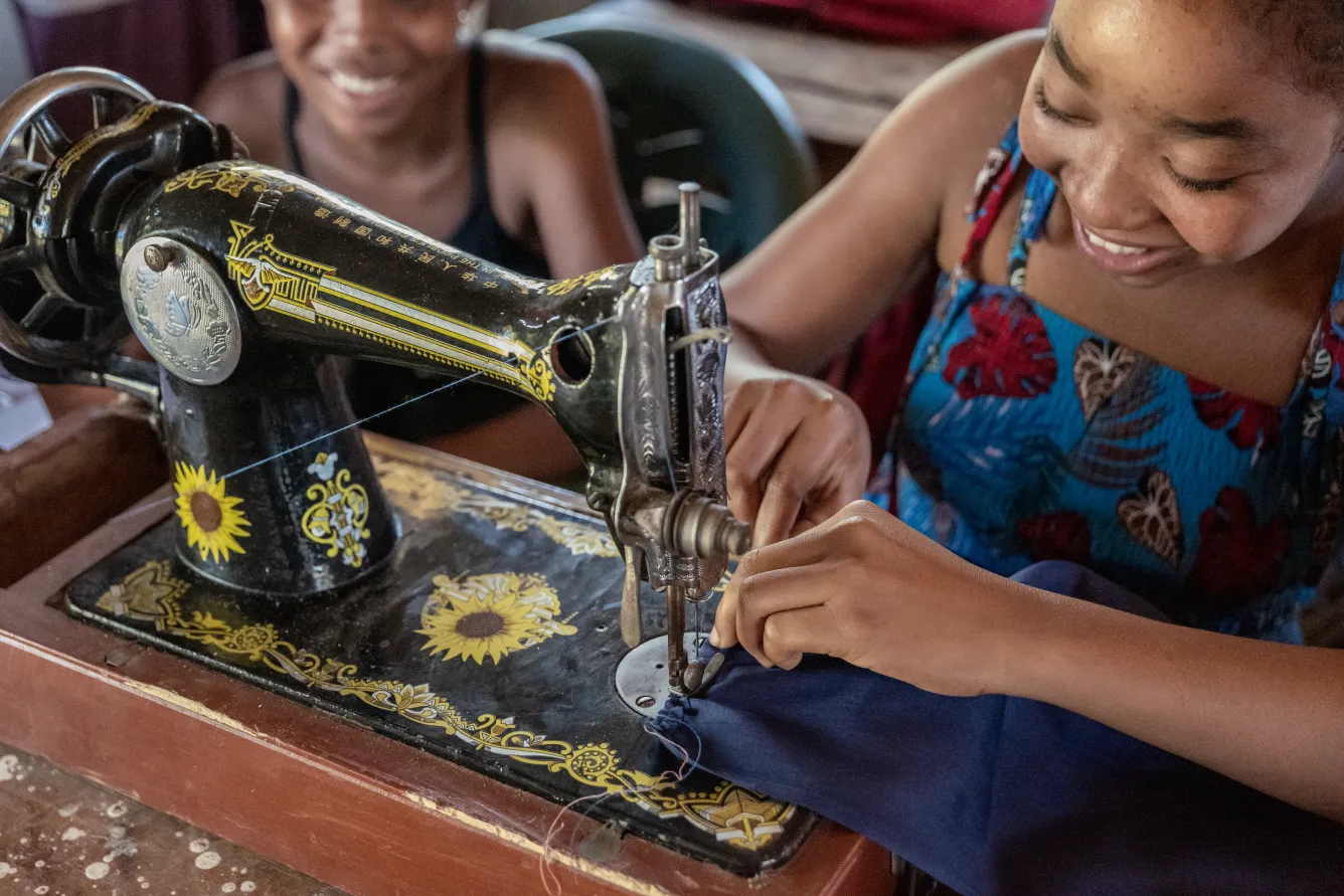 Gislène, an 18-year-old seamstress in training, operates her sewing machine with skill.