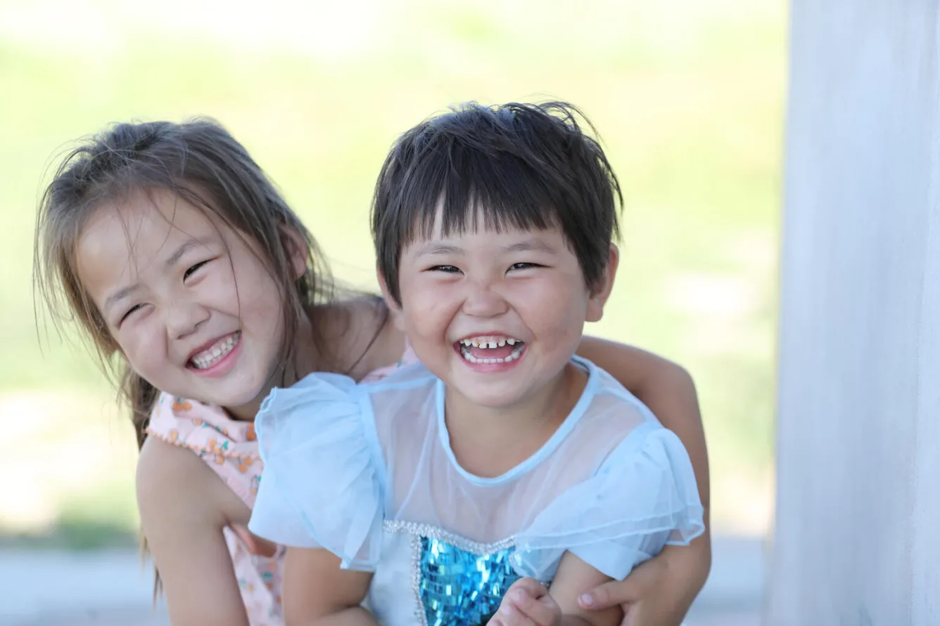 Two girls in Mongolia laughing.