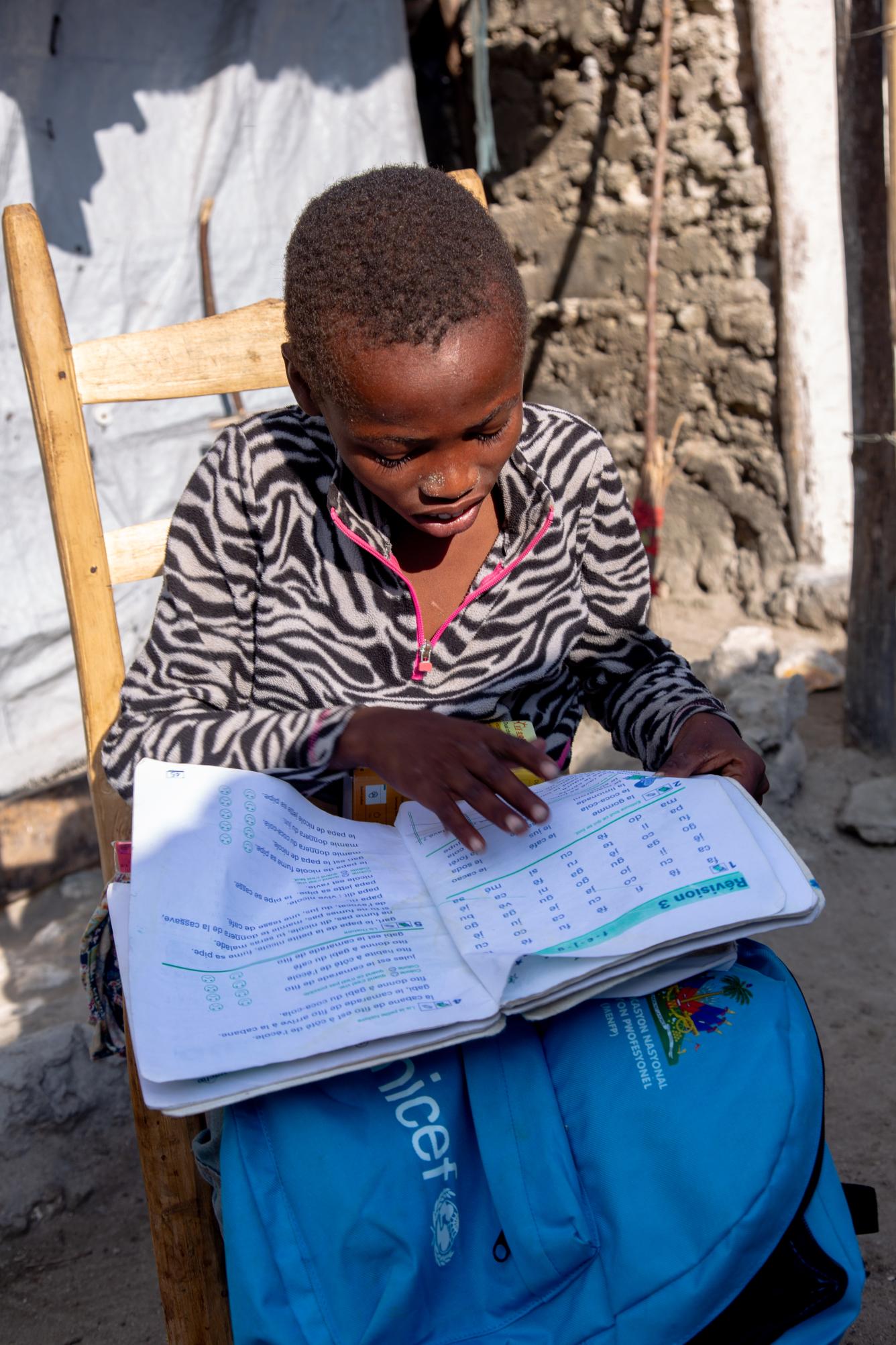 Jean Max, 12 ans, fait ses devoir à la maison, le lendemain de la distribution des kits scolaires à l’école La Haie, Grand'Anse.