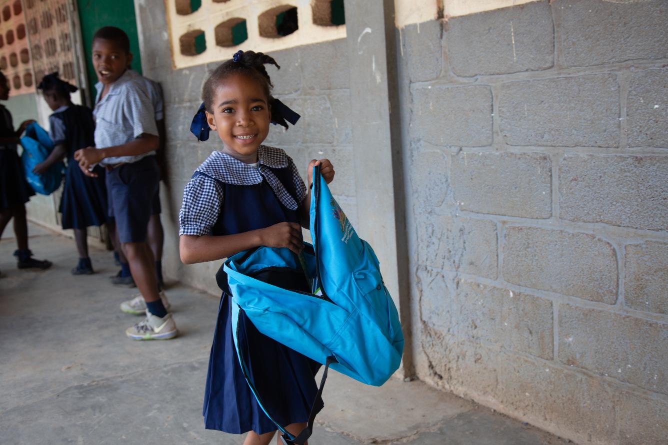 Une élève contente de recevoir son kit scolaire.
