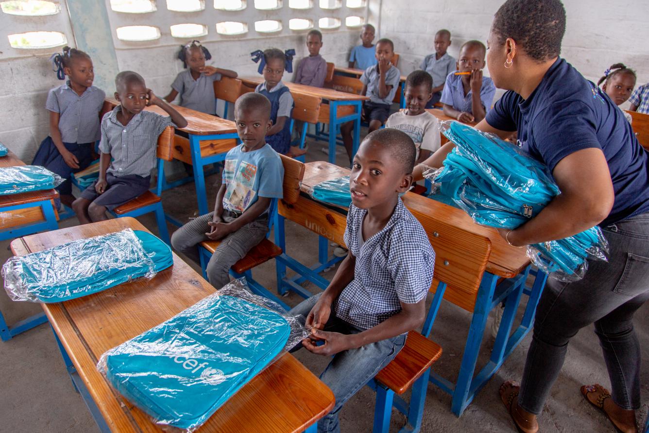 Darlee Labranche, charge de l’éducation de l’UNICEF distribue des matériels scolaires aux élèves de l’Ecole nationale de Morency, Sud, Haiti.
