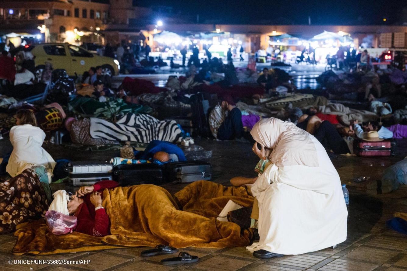 Several residents sit or lie down on blankets in the city square in Marrakesh after an earthquake.