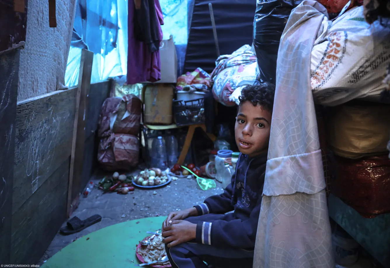 10-year-old Mohammed sits inside his family's makeshift tent in a shelter for internally displaced persons in Rafah, southern Gaza Strip.