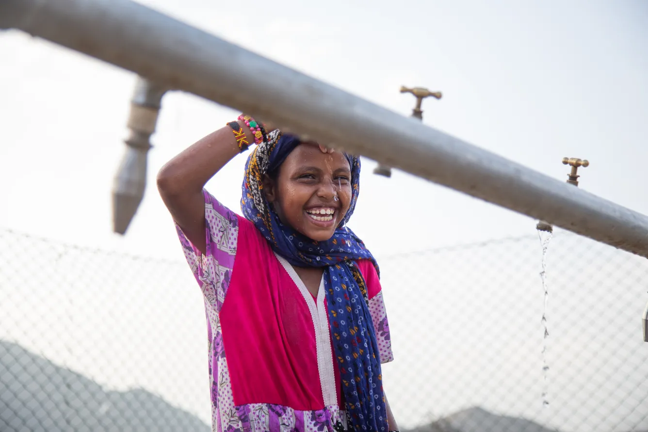 7-year-old Madina Mohamed Awad collects water at a new water station in the small village of Gelhanty in Agig locality, Red Sea state.