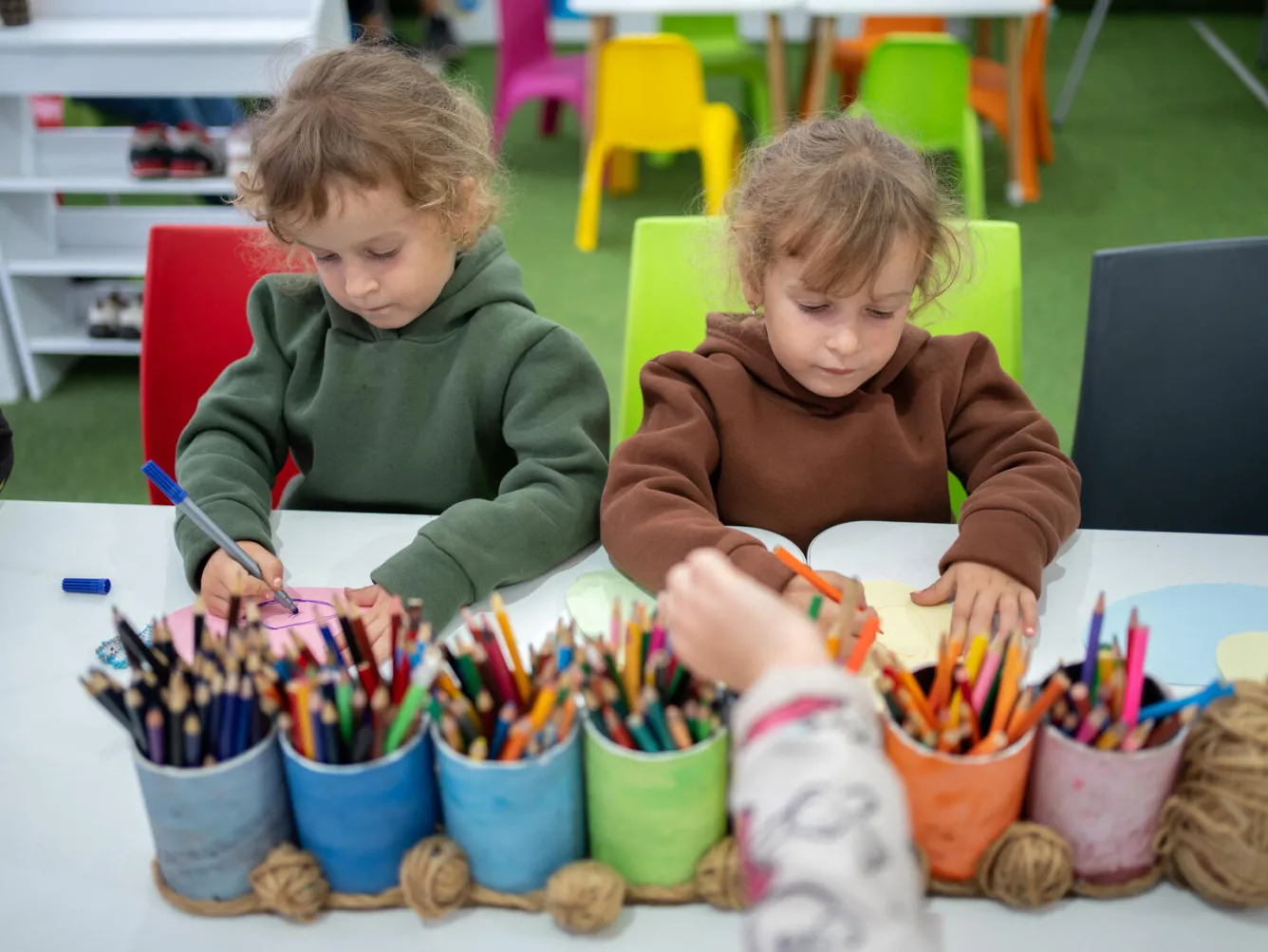 Two girls draw at the UNICEF Spilno Child Spot in Balakliya, Ukraine.