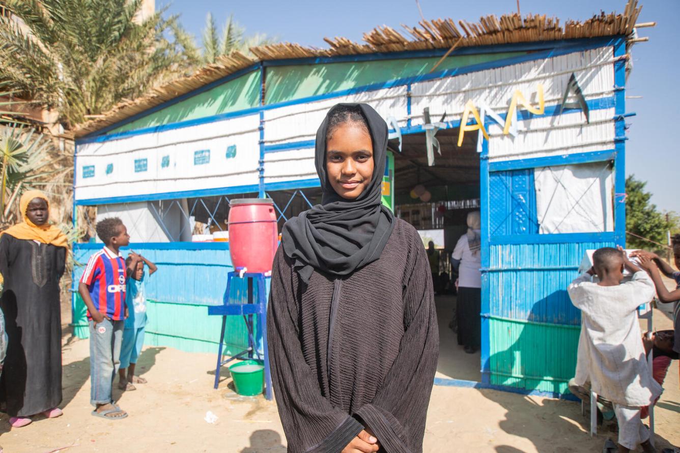 In Sudan, Fourteen-year-old Shaimaa stands at a UNICEF-supported Makanna, or child-friendly safe space.