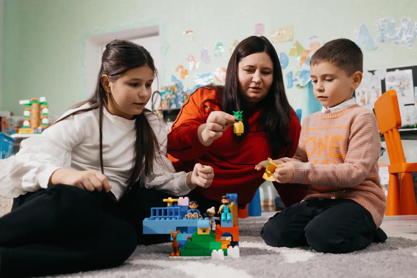 A mother and her son and daughter play a UNICEF-supported play and learning hub in Balti, Moldova.
