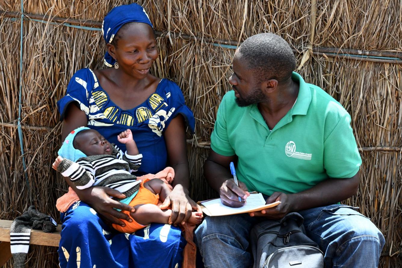Au Cameroun, un travailleur de la santé enregistre un bébé que sa mère tient dans ses bras.