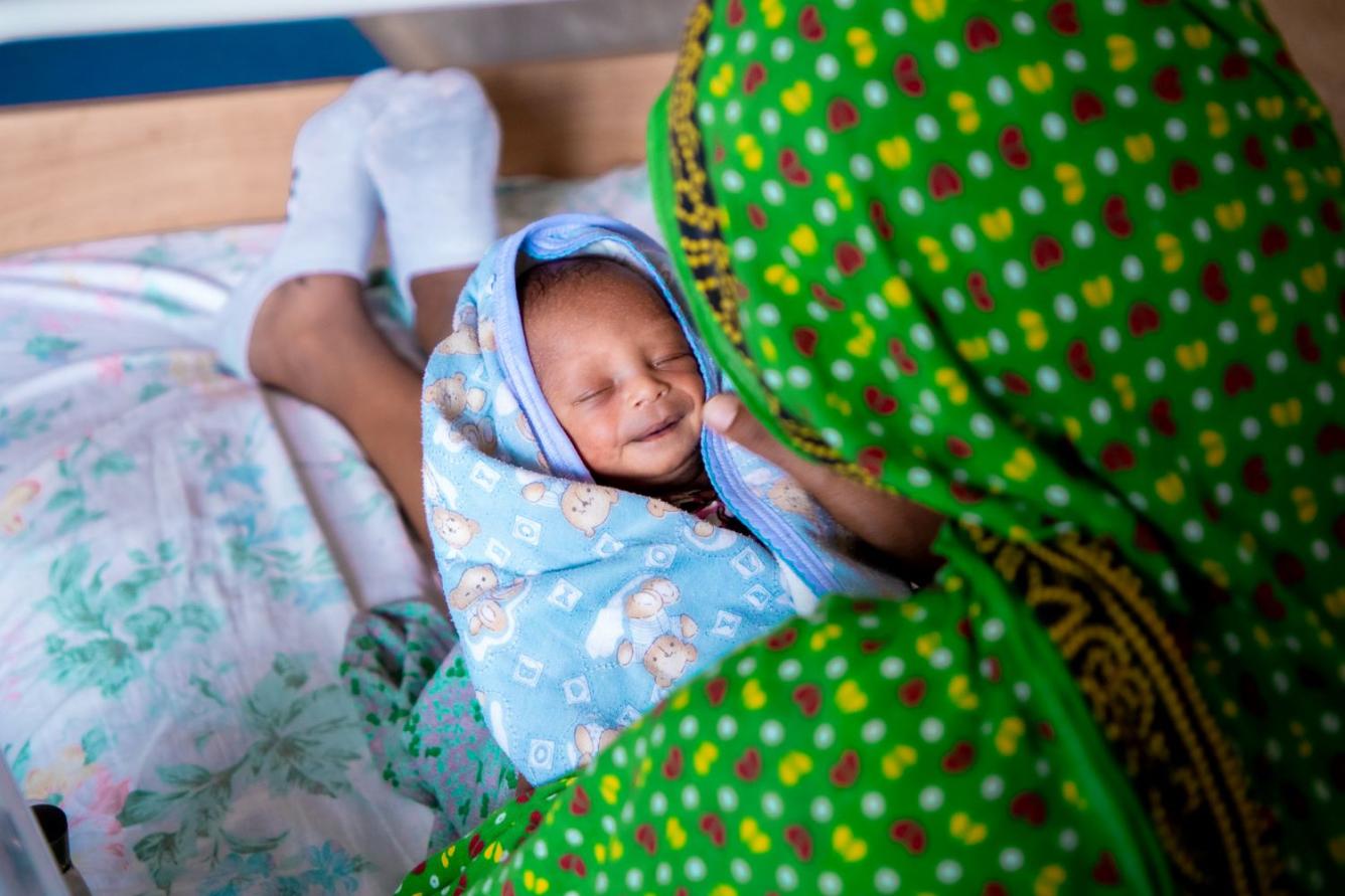 Dans un hôpital en Éthiopie, une mère tient dans ses bras son bébé enveloppé dans une couverture.