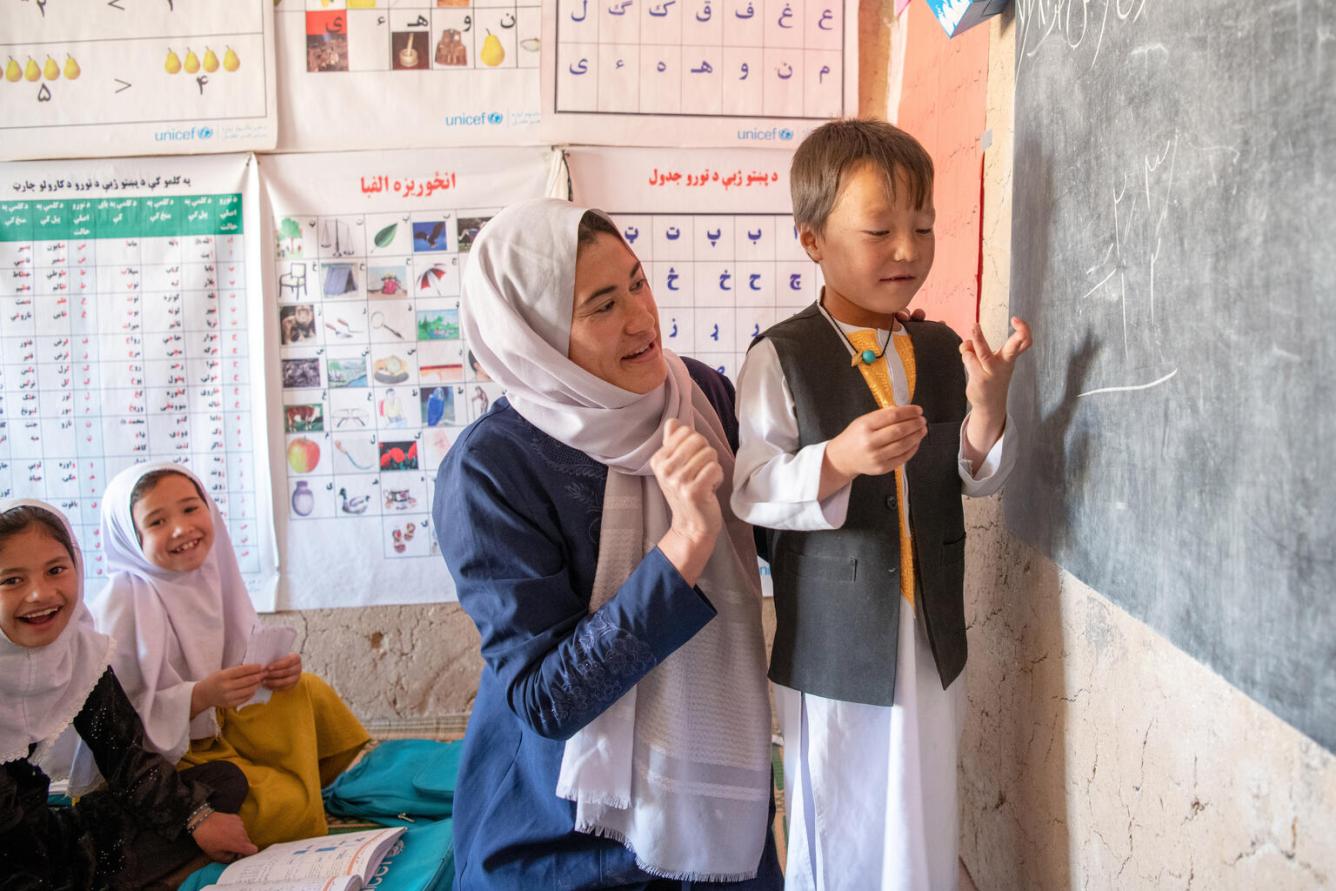 L’enseignante Ruqiya aide le jeune Milad, âgé de sept ans, avec ses mathématiques dans la salle de classe communautaire soutenue par l’UNICEF.