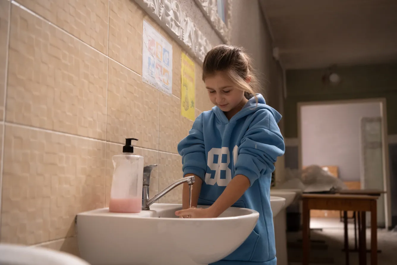 A student washes her hands at school, where hot water is always available. The provision of safe and stable water encourages regular hygiene practices, offering a sense of normalcy and security for students amid the ongoing war.