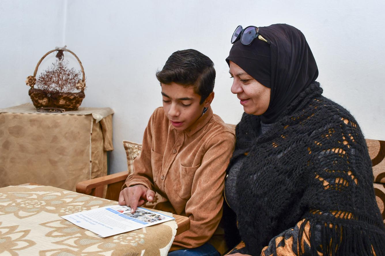 Mohammed shares the knowledge he has learned at the UNICEF-supported child-friendly space with his mother in their home in Bseimeh village, Rural Damascus.