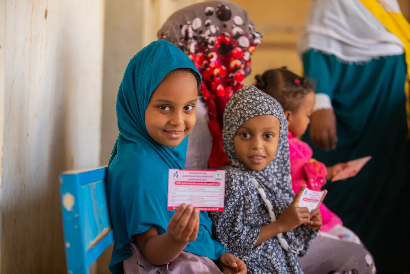 Une petite fille montre sa carte de vaccination après avoir été vaccinée contre la rougeole et la rubéole dans l’État de Kassala, au Soudan.