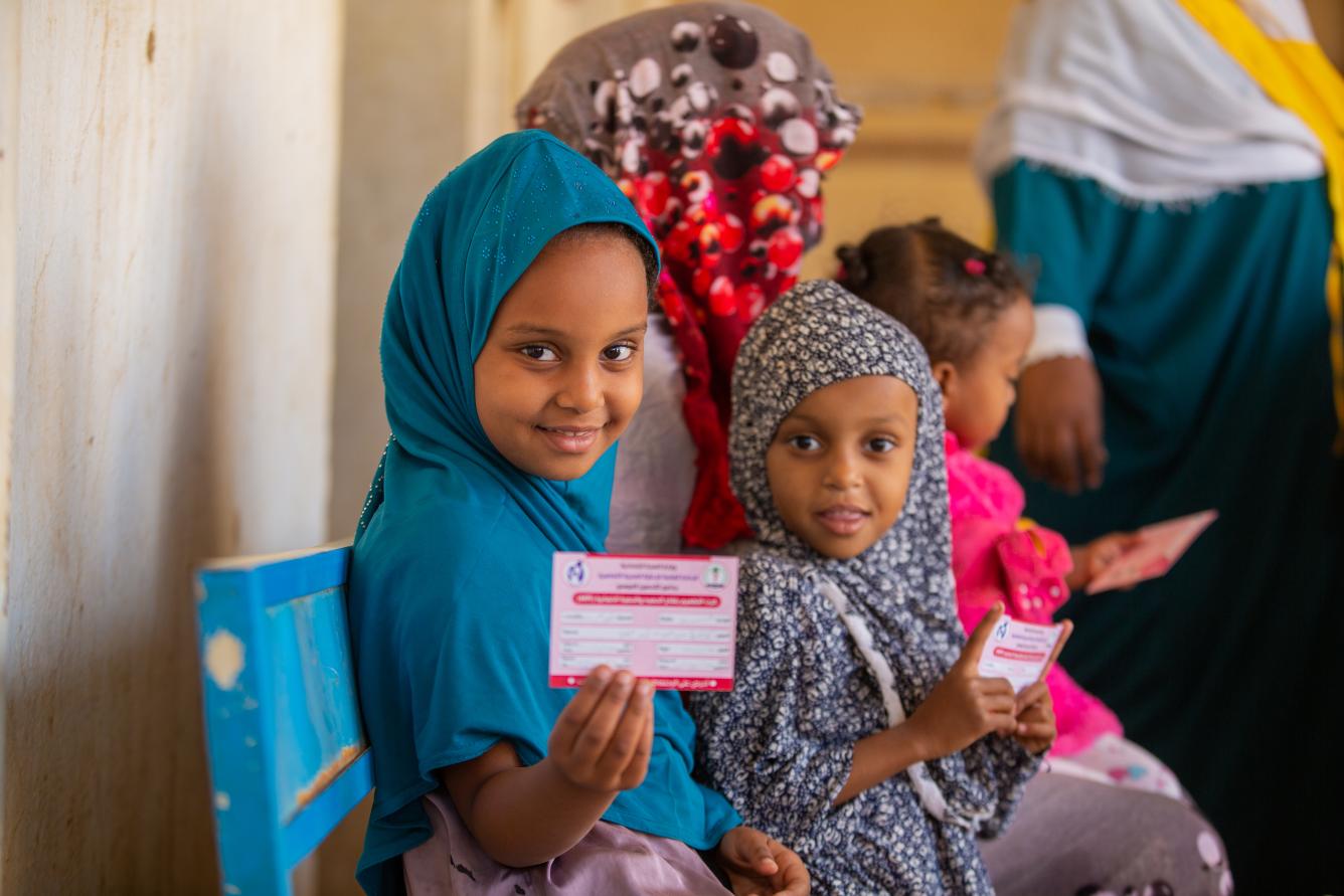 A young girl flashes her vaccination card after she was vaccinated against measles and rubella in Kassala state, Sudan
