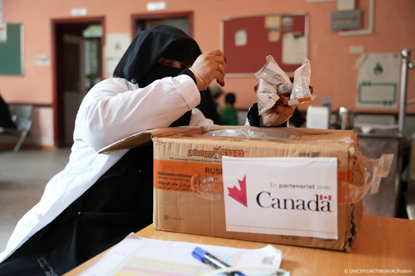 Une travailleuse de la santé déballe une boîte d’aliments thérapeutiques prêts à l’emploi fournie par l’UNICEF avec le soutien du gouvernement du Canada.