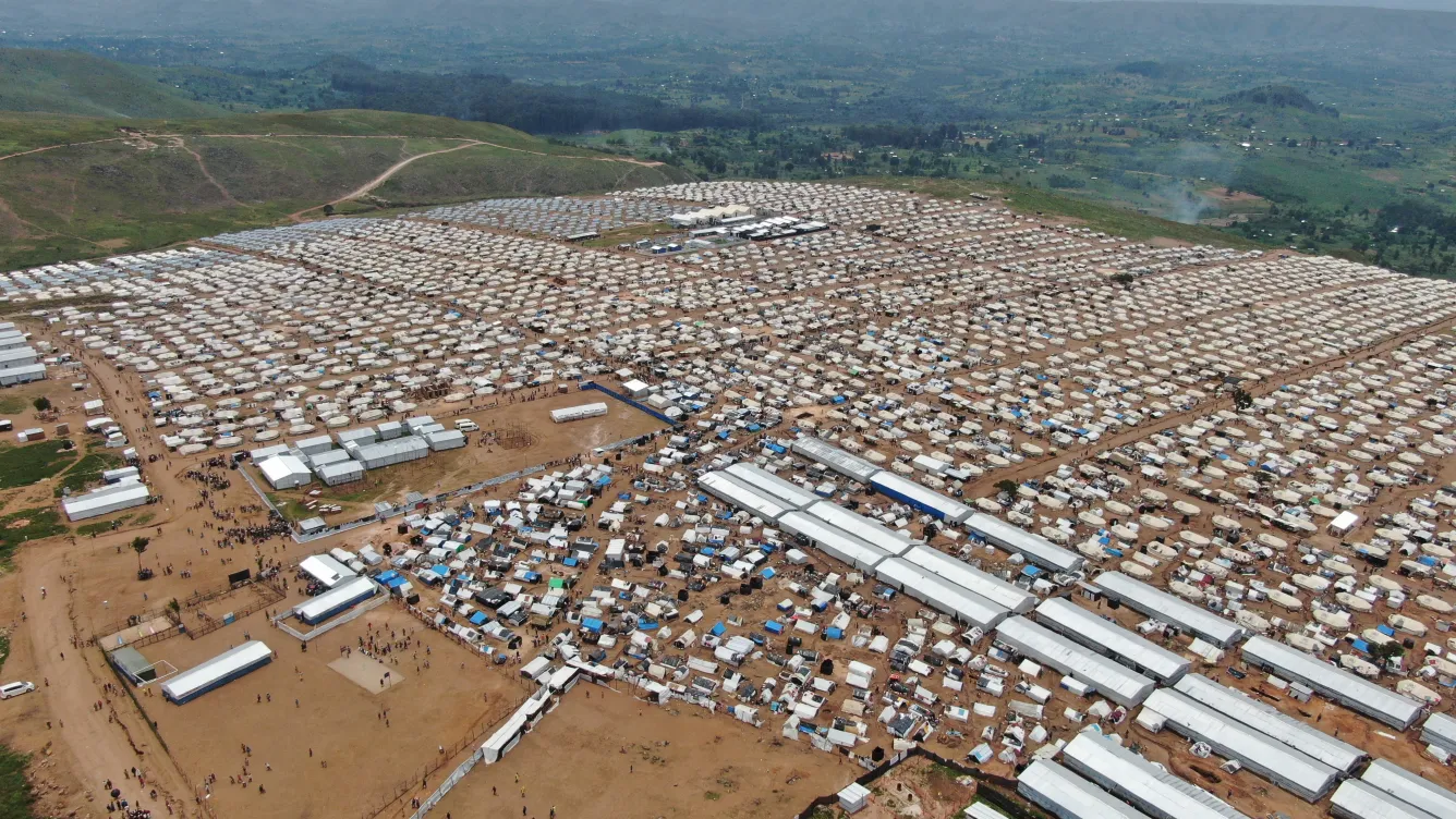 Aerial view of a vast, densely packed settlement of thousands of small tents and temporary shelters