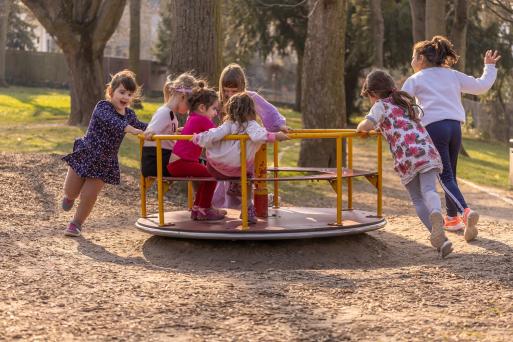Un groupe d’enfants jouant sur un manège dans un terrain de jeu.