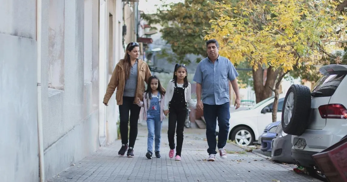 A migrant family walks down a street in Uruguay.