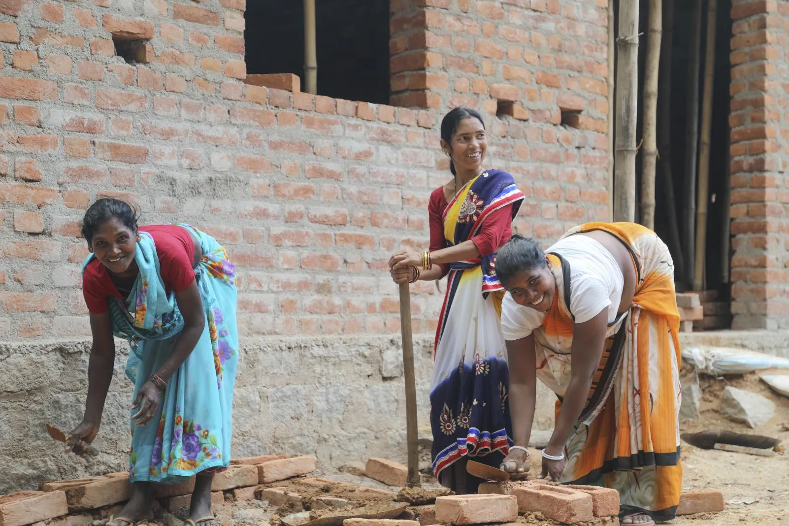 Three rani mistris work at digging a new toilet.