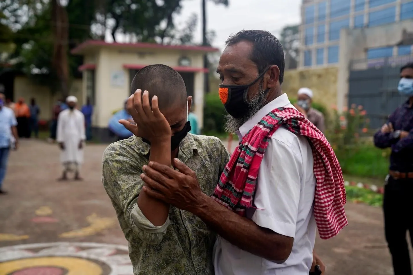 A man consoles his son who was just released from a youth detention centre for migrants.