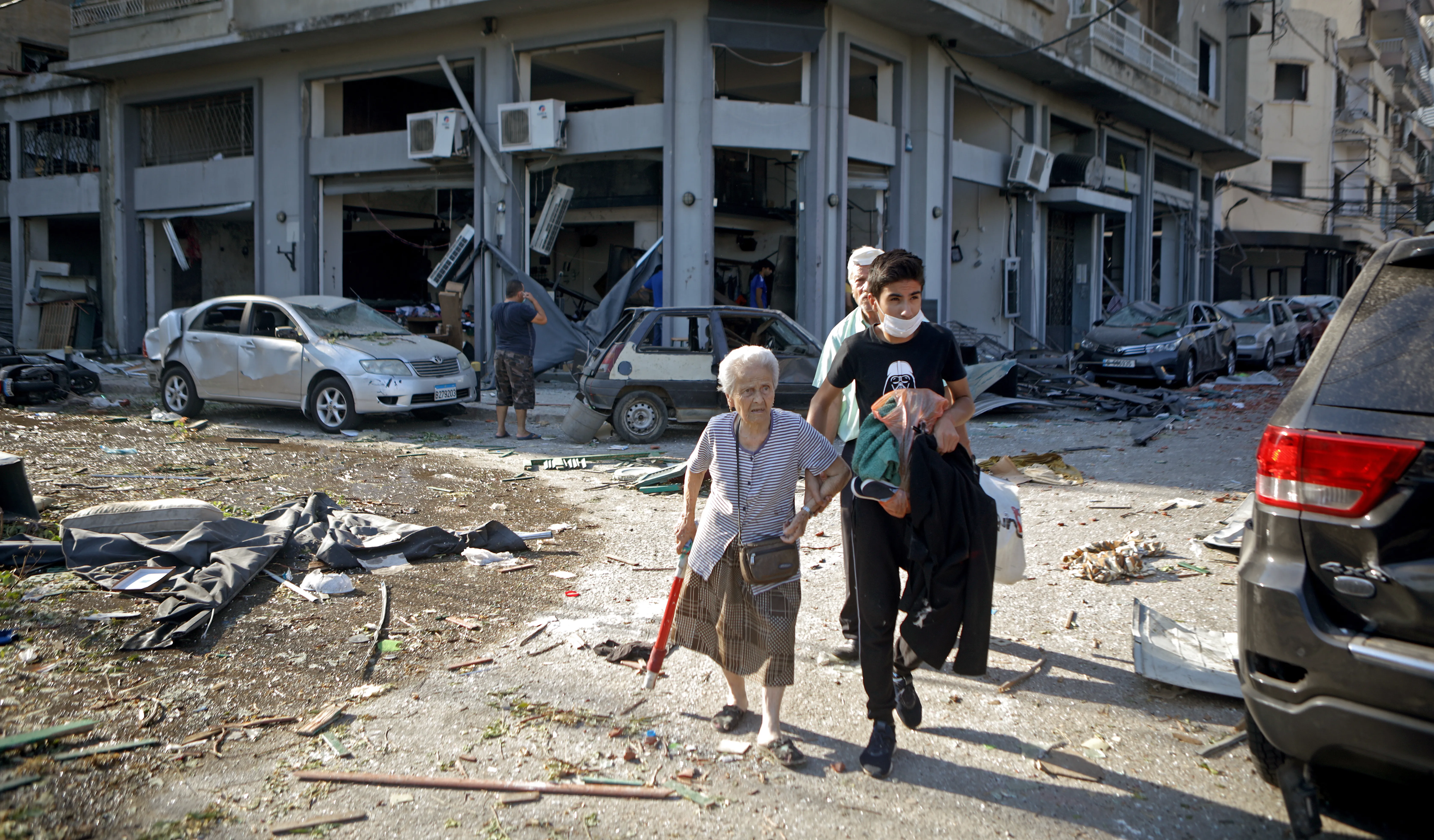 A woman is evacuated from the partially destroyed Beirut neighbourhood of Mar Mikhael on August 5, 2020 in the aftermath of a massive explosion in the Lebanese capital. - Rescuers searched for survivors in Beirut today after a cataclysmic explosion at the port sowed devastation across entire neighbourhoods, killing more than 100 people, wounding thousands and plunging Lebanon deeper into crisis.