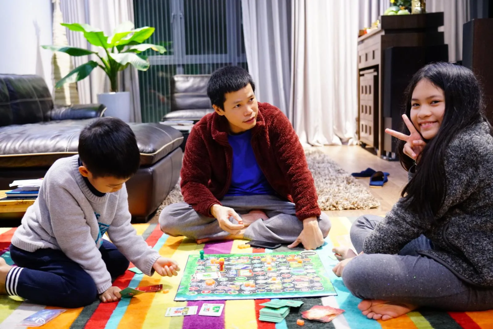 A family plays a board game at home together in Vietnam.