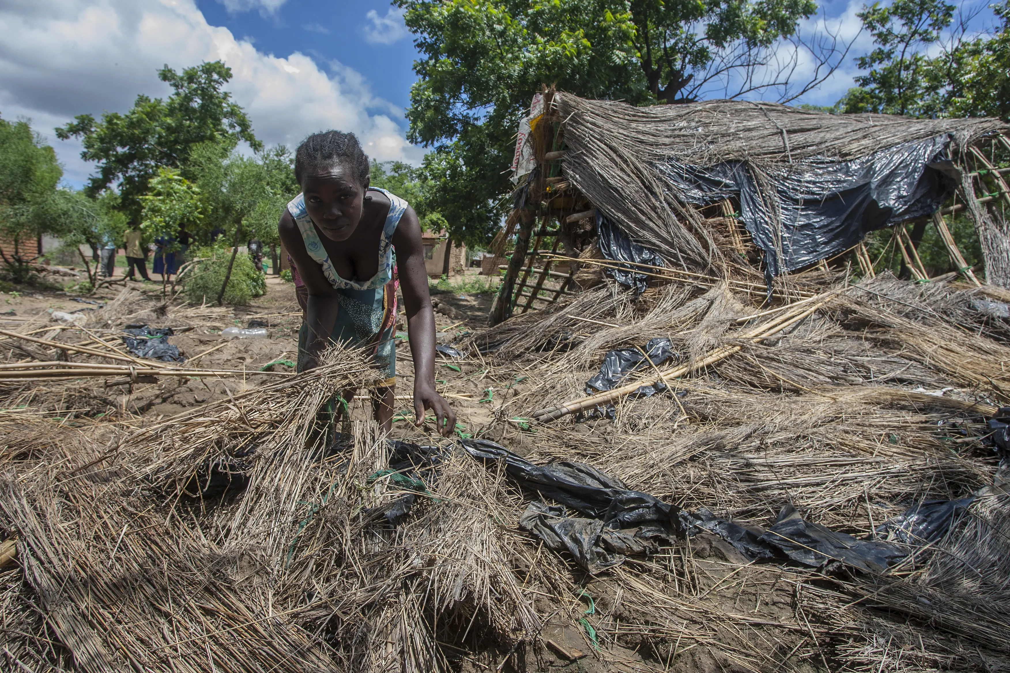 A woman searches through her destroyed home.