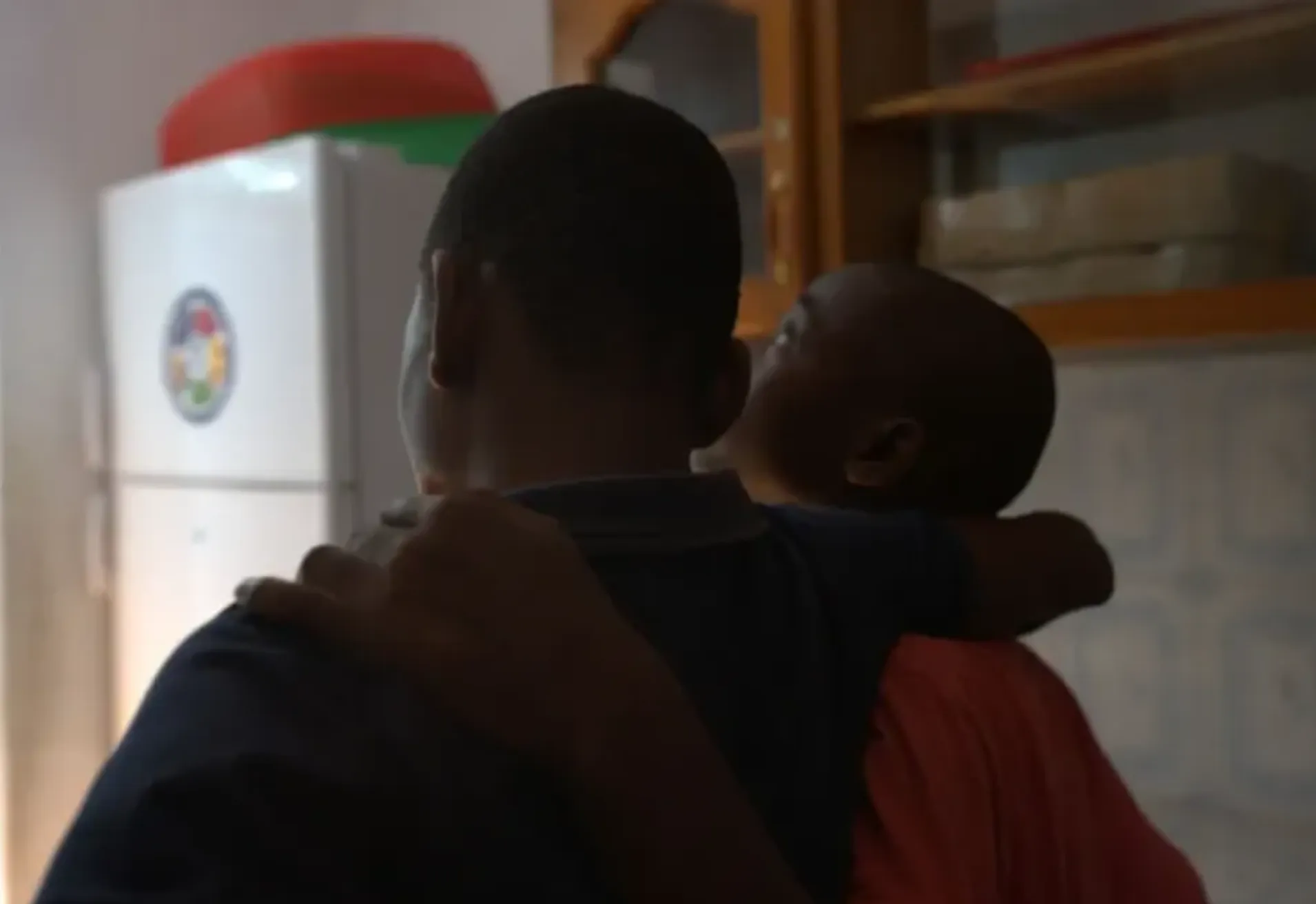 Two children with their backs turned to the camera looking out