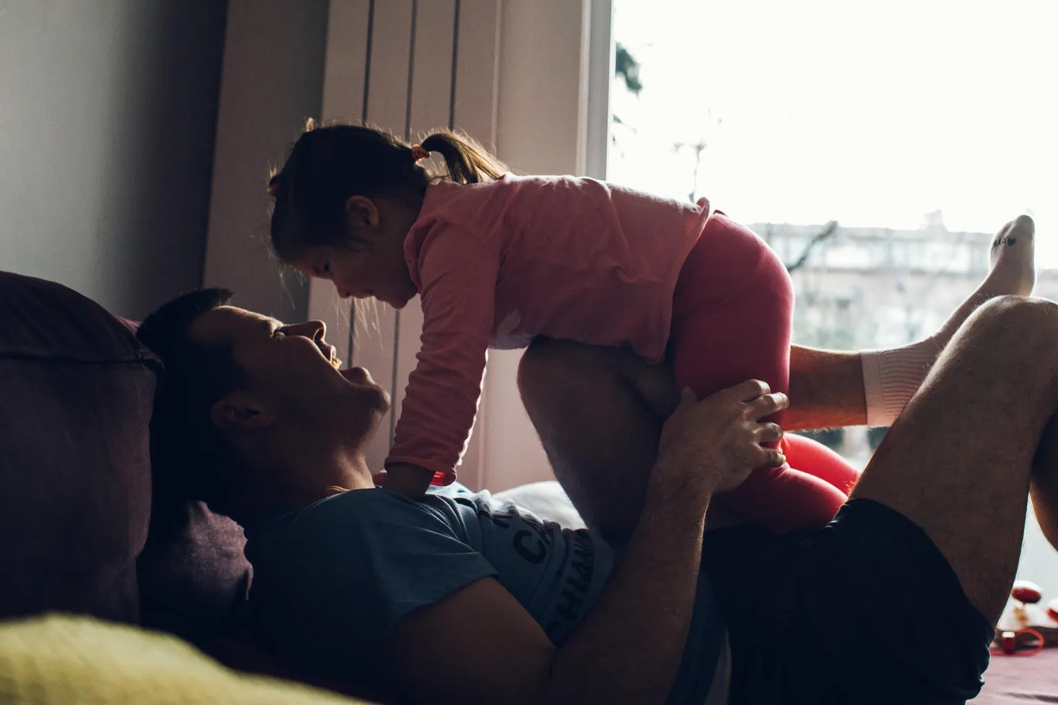Father playfully lifting his daughter in the air